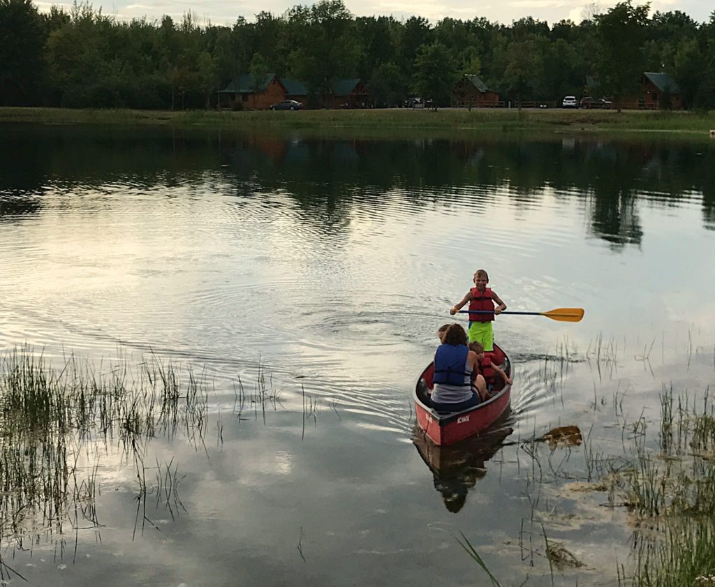 children canoeing on the pond at Branches of Niagara campground
